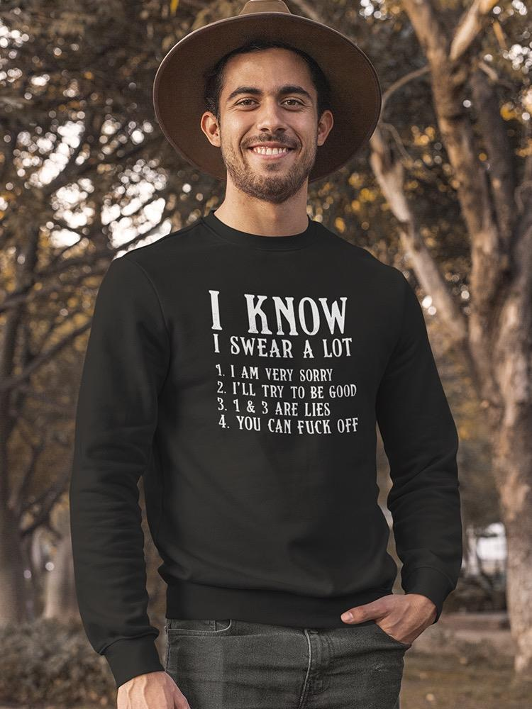 Man wearing a black sweatshirt with text outdoors
