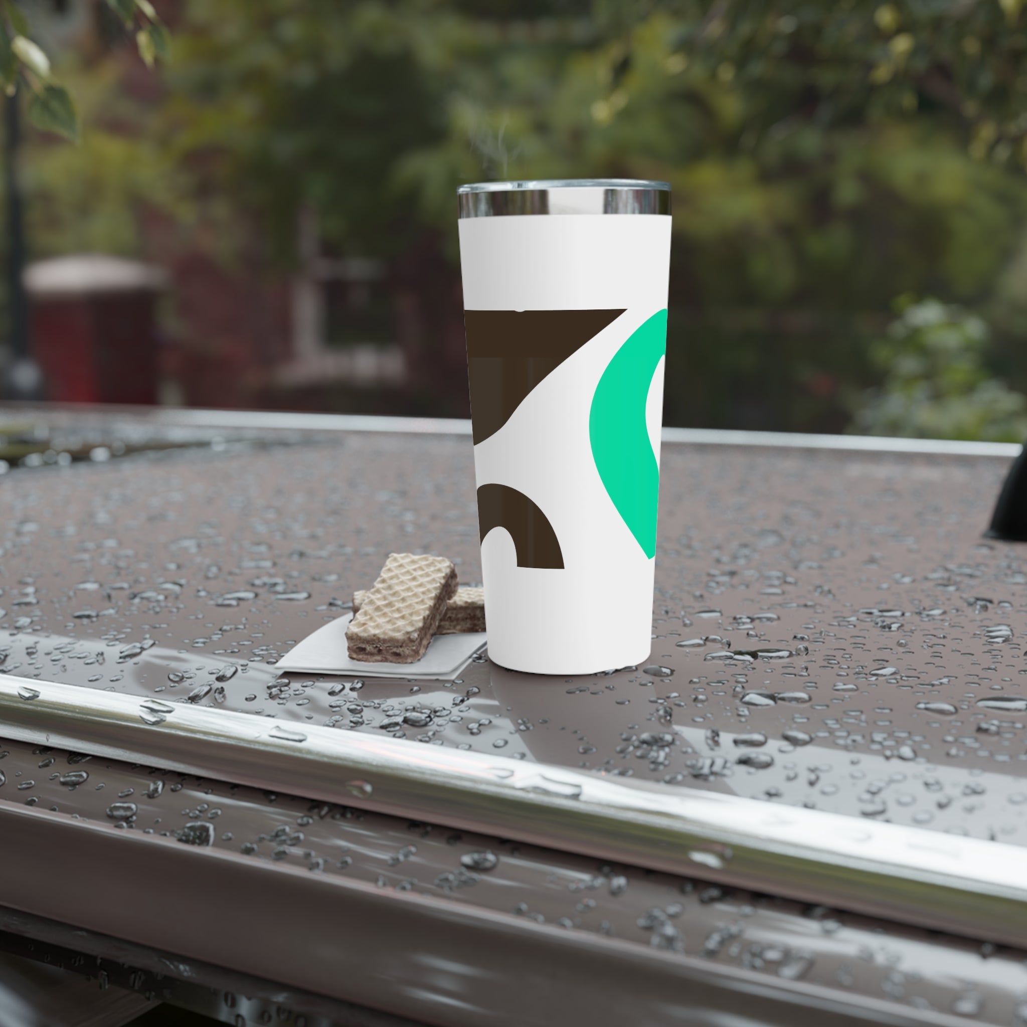 White tumbler with a logo on a wet surface outdoors