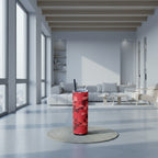 Red camouflage-patterned tumbler with a black straw on a white background