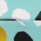 Close-up of a zipper on a fabric with cloud and sun patterns.