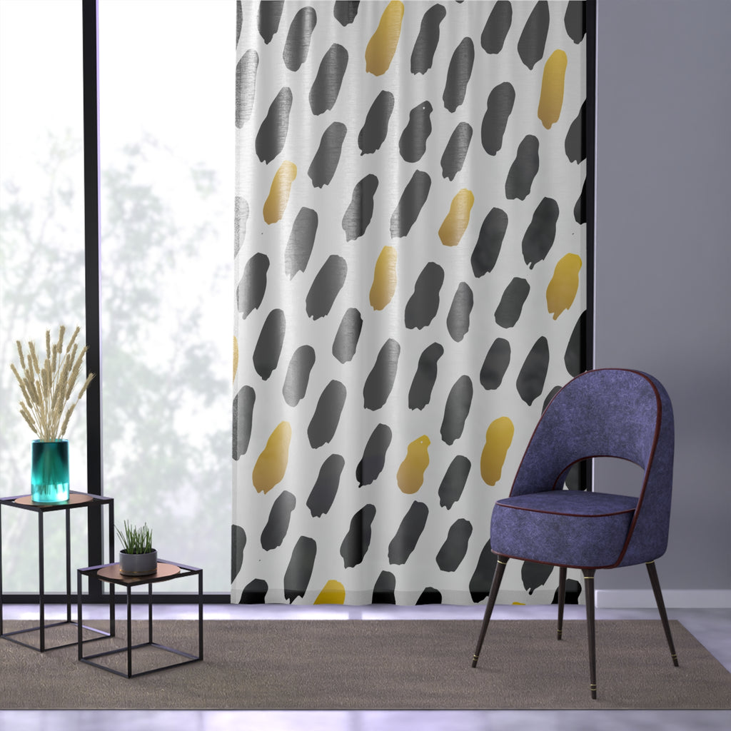 Patterned curtain with abstract design in a room with a chair and small tables.