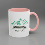 White mug with pink interior and handle featuring green mountain graphic and text.