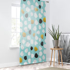 Colorful polka dot curtain in a room with a plant and decor items.