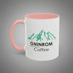 White mug with pink interior and handle, featuring green mountain design and text on a white background