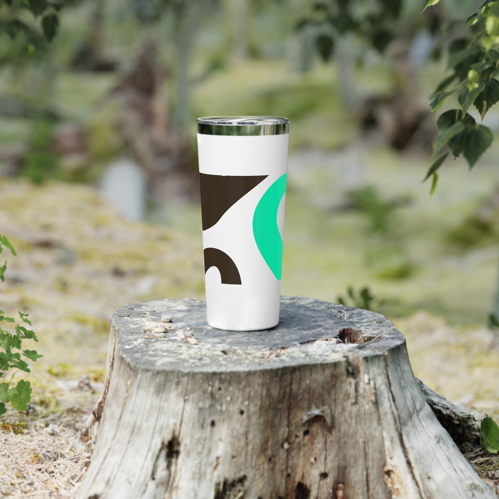 Tumbler with abstract design on a wooden stump in a natural setting